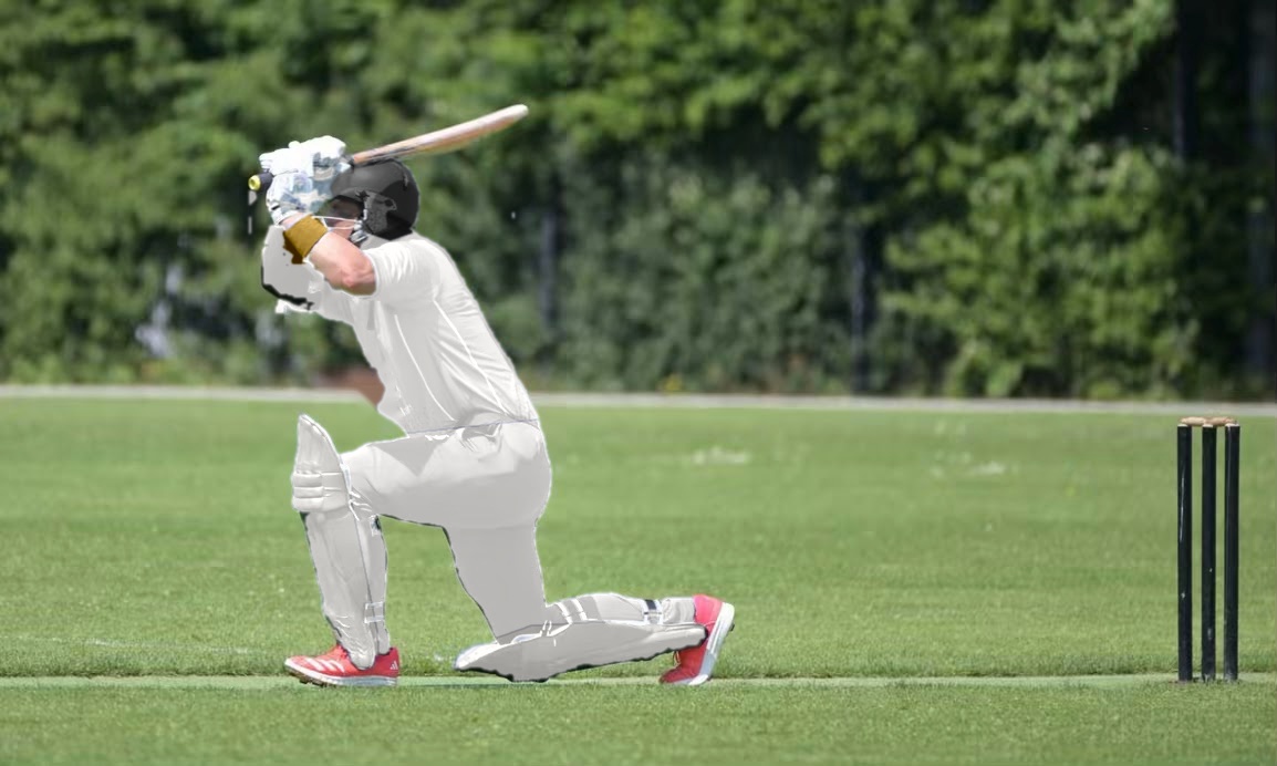 Cricketer playing a drive shot on an outdoor pitch