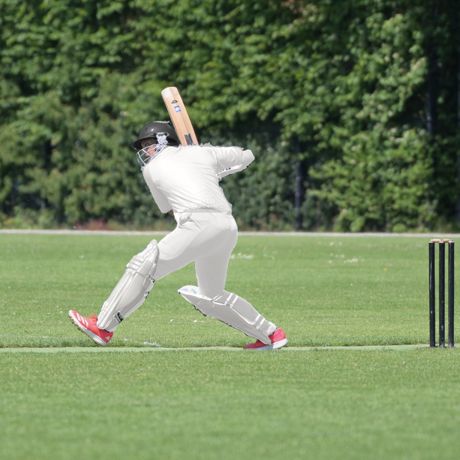 Cricketer playing a back-foot shot on an outdoor pitch